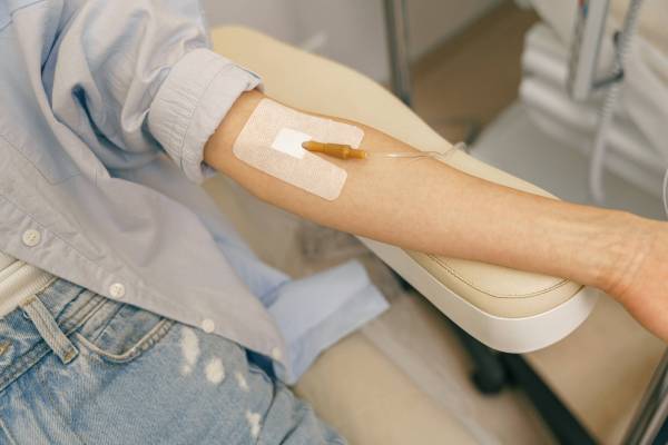 Close up of woman hand with medical drip or IV drip in hospital ward. High quality photo